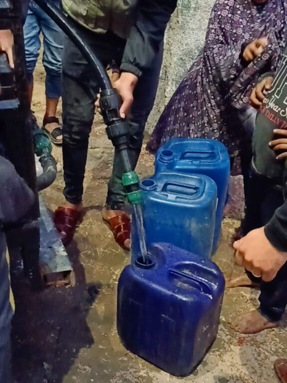 Portable Water Vehicle Delivers Water to Families in Gaza Volunteer filling the water containers for the children.